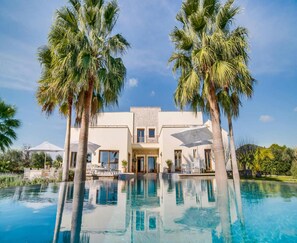 A modern house with a pool, surrounded by palm trees. - Spacious Villa With Infinity Pool (Son Servera)
