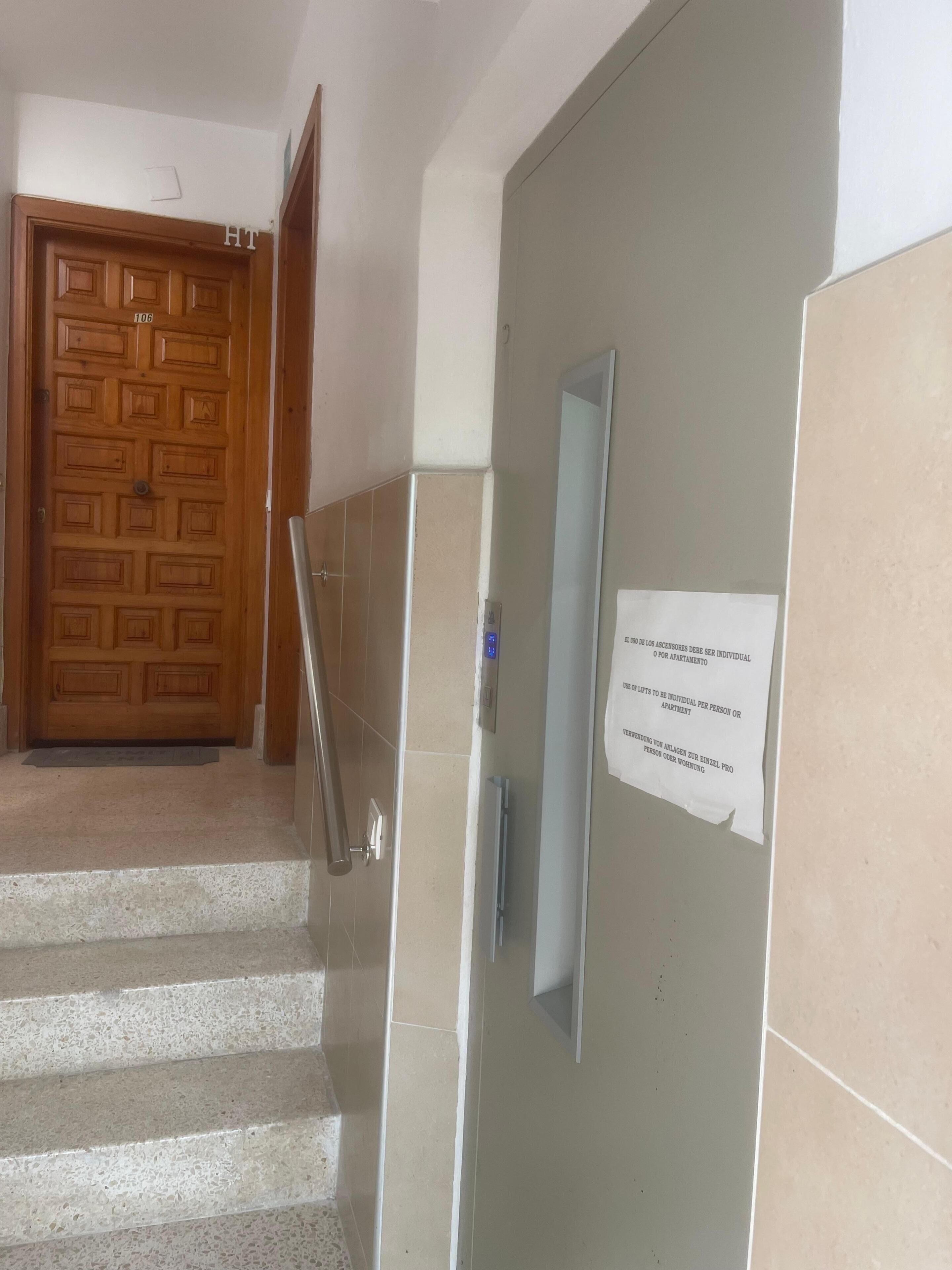 A staircase leading to a room with a wooden door and a sign on the wall.
