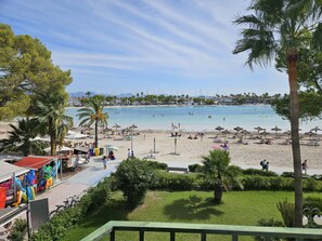 Une plage avec des parasols, des chaises longues et une vue dégagée sur la mer.