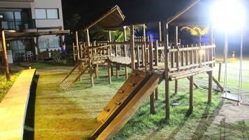 A playground with wooden structures and a slide.