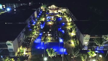 A hotel with a pool area, outdoor seating, and a covered section.