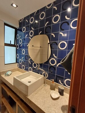A bathroom with a large sink, a mirror, and a window. -  Polinesia Resort - Porto de Galinhas - Acesso ao Hotel Samoa.  (Ipojuca)