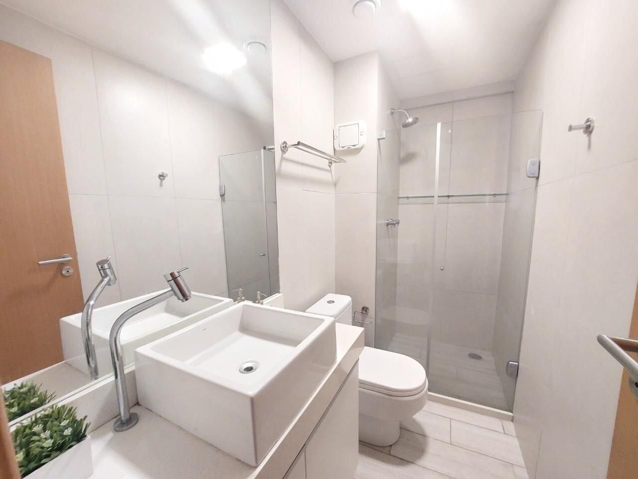 Un baño moderno con un lavabo grande, inodoro y ducha con mampara de vidrio.