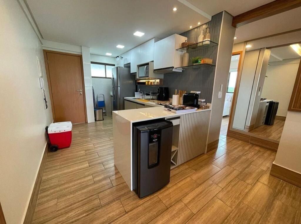 A compact kitchen with modern appliances, a small refrigerator, and a microwave.