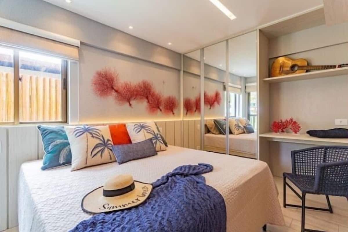 A modern bedroom with a bed, a hat, and a chair.