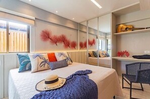 A modern bedroom with a bed, a hat, and a chair. -  Polinesia Resort - Porto de Galinhas - Acesso ao Hotel Samoa.  (Ipojuca)