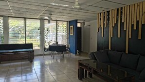 A spacious room with a large window, a sofa, a table, and a bench. - Quinta Kartagus (Santa Tecla)