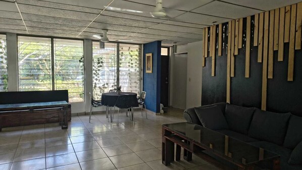 A spacious room with a large window, a sofa, a table, and a bench. - Quinta Kartagus (Santa Tecla)