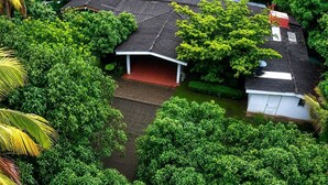Une maison entourée d’une végétation luxuriante, dotée d’un porche abrité et d’une antenne parabolique.