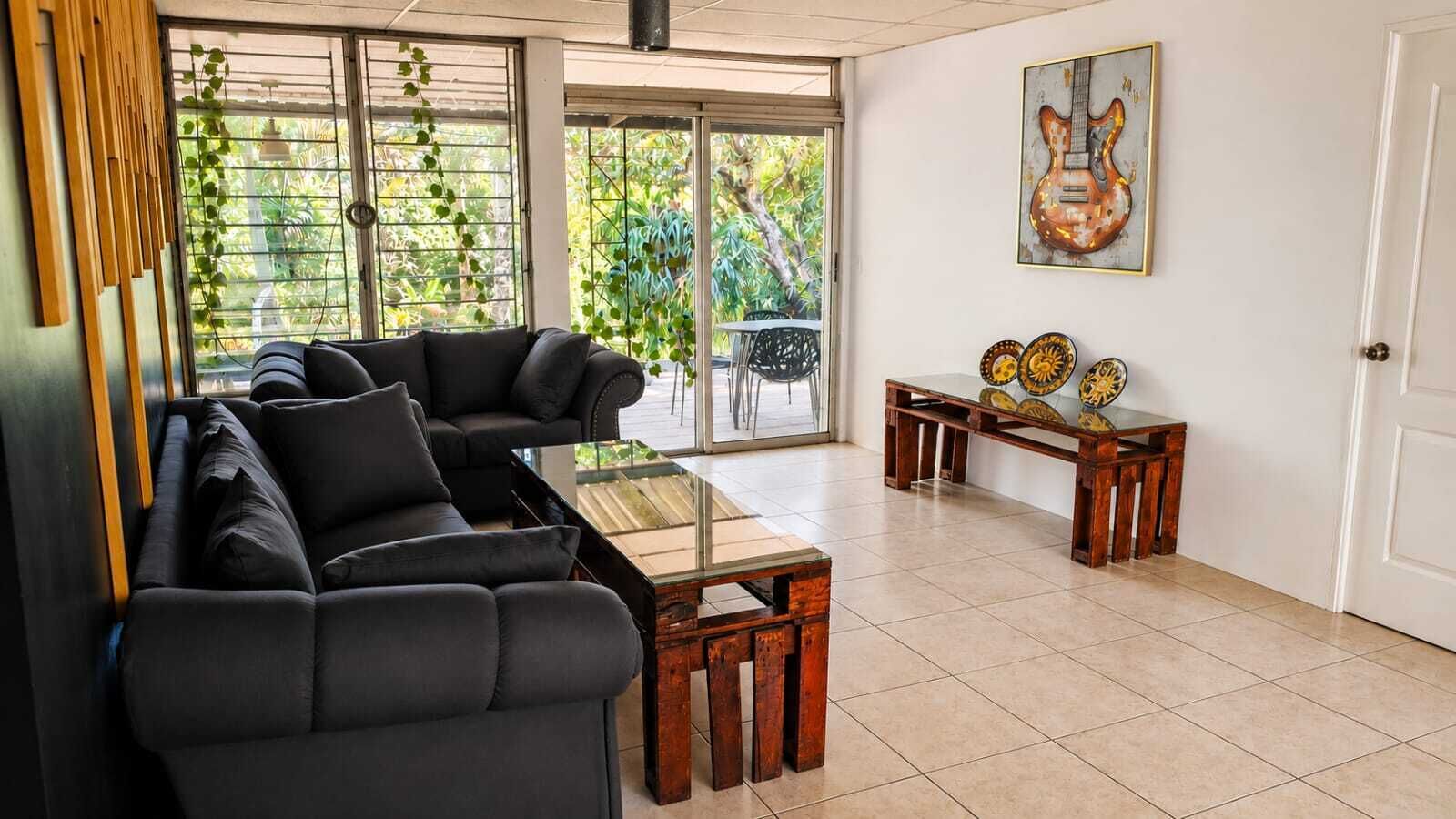 A living room with a sofa set, a coffee table, and a dining table with decorative plates.