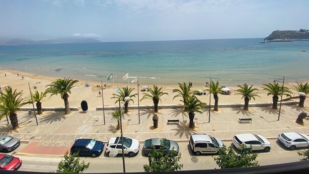 A beach view with parked cars and palm trees. - A step away from the beach, first line, incredible views brand new! (Puerto de Mazarrón)
