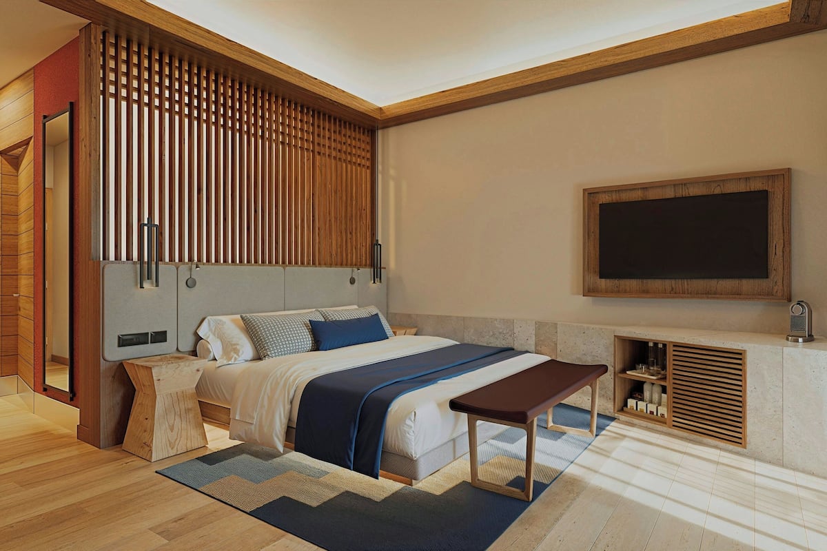 Un dormitorio moderno con cama, mesita de noche y televisor integrado.