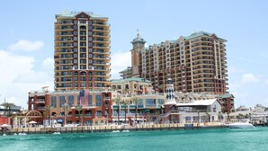 Ein Hotel am Wasser mit mehreren Hochhäusern, einer gut sichtbaren amerikanischen Flagge und einem Yachthafen mit Booten.