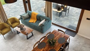 A modern living room with a sofa, coffee table, and dining table. - Vacation home near Swinemünde, in the countryside / Baltic Sea, quiet location - dogs welcome (Kołczewo)