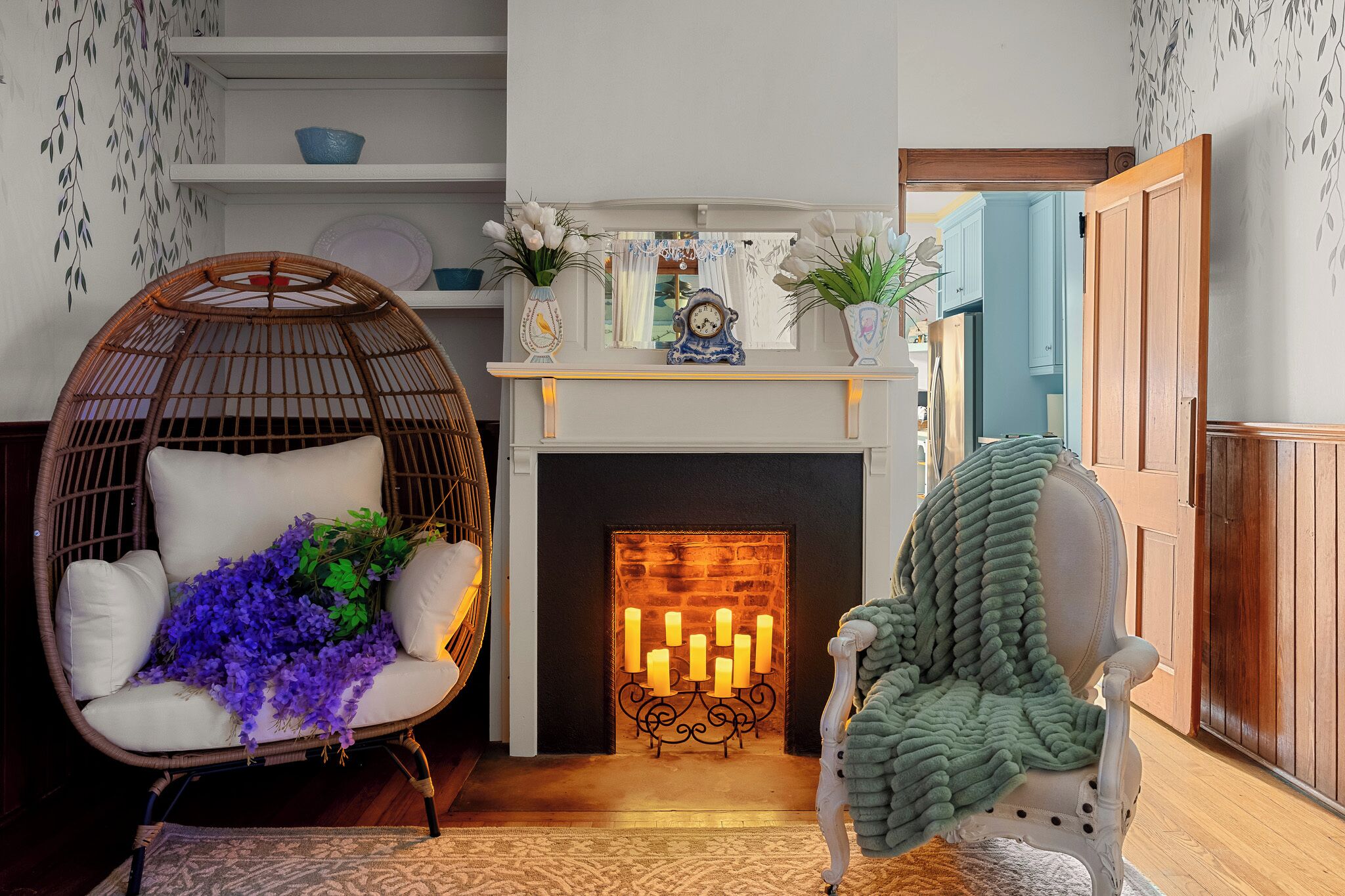 A cozy living room with a fireplace, wicker chair, and a green throw blanket.