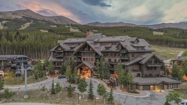 A large lodge with multiple balconies and a ski lift in the background.