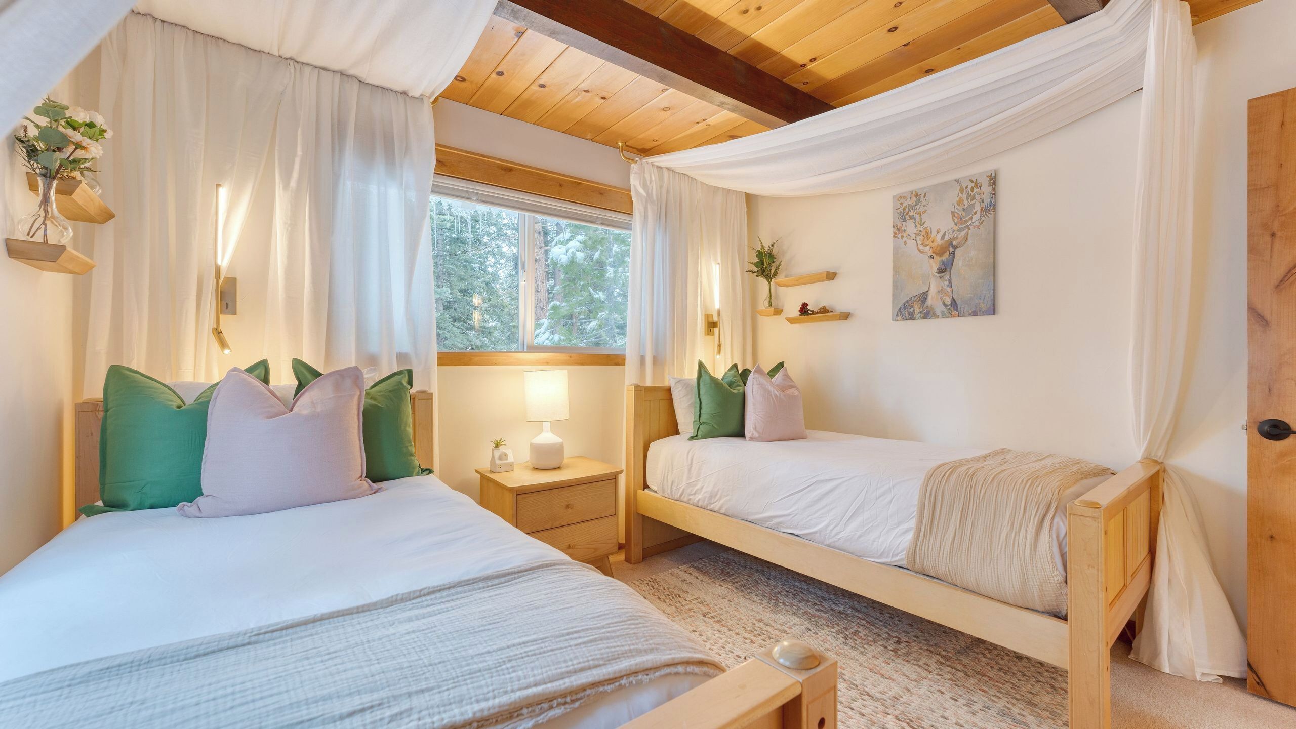 Ein gemütliches Schlafzimmer mit zwei Betten, einem Nachttisch, einer Lampe und einem Bild an der Wand.
