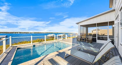 Lagoon front home with podium pool, ice machine, and washer and dryer