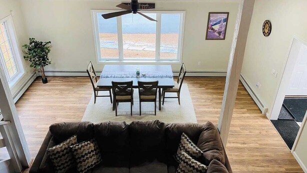 A dining area with a table and chairs, a ceiling fan, and a view of the outdoors. - Charming 2-bedroom house with AC, WiFi in North Conway (North Conway)