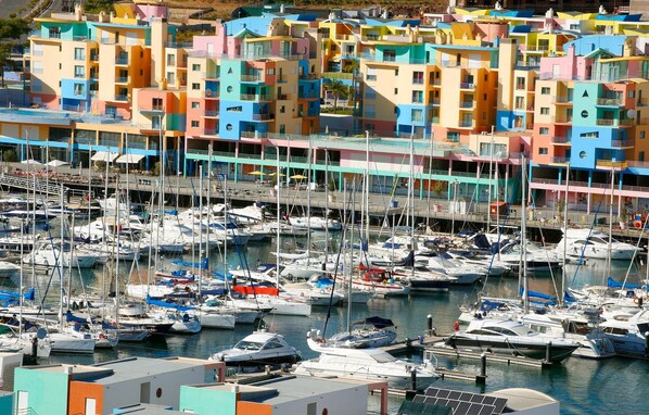 A marina with colorful buildings and numerous boats docked. - Kimpton Atlantico Algarve (Albufeira)