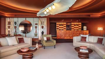 A modern lounge area with sofas, a coffee table, a reception desk, and decorative vases.