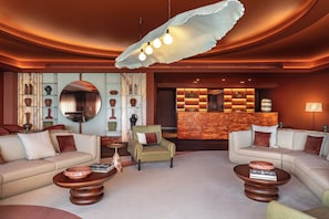 A modern lounge area with sofas, a coffee table, a reception desk, and decorative vases. - Kimpton Atlantico Algarve (Albufeira)