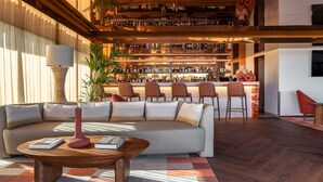 Zona bar moderna con diverse opzioni di seduta, un divano e un bancone.