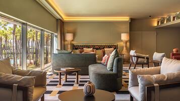 A modern living room with a sofa, armchairs, a coffee table, and a lamp.