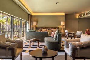 A modern living room with a sofa, armchairs, a coffee table, and a lamp. - Kimpton Atlantico Algarve (Albufeira)