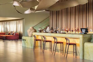 A bar area with a marble counter, bar stools, and a large vase. - Kimpton Atlantico Algarve (Albufeira)