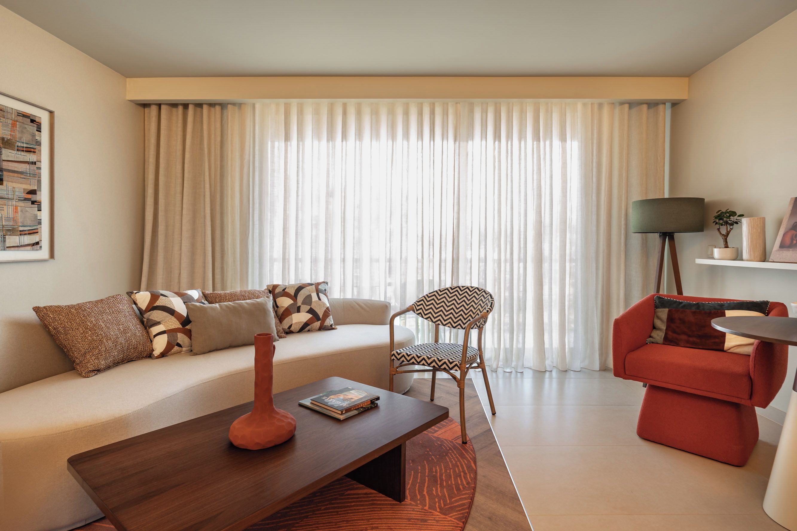 A modern living room with a sofa, a chair, a coffee table, and a lamp.