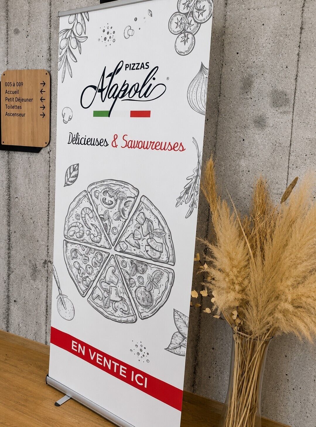 En skylt för ”Pizzas Apol” med en illustration av en pizza och pilar som visar vägen till hotellets olika faciliteter.