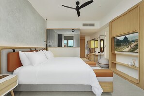 Quarto de hotel moderno com uma cama grande, ventoinha no teto, televisão e vista para uma paisagem montanhosa.