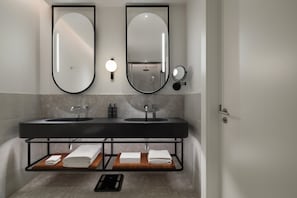 A modern bathroom with two sinks, a large mirror, and a towel rack. - Siro Porto Montenegro (Tivat)