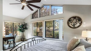 A bedroom with a large bed, a ceiling fan, a desk with a chair, and a potted plant. - Doras Dream, 4 Bedrooms, Sleeps 12, Downtown (Mount Dora)