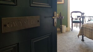 A dark green door with a brass plate reading "GWYNNEDD" and a keyhole. - Afallon Townhouse (Dolgellau)