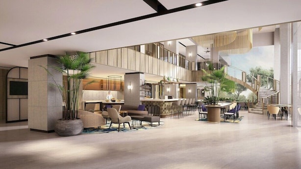 A spacious lobby with a bar area, seating, and a staircase leading to upper floors. - Mercure Madiun (Madiun)