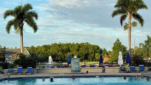 Ein Swimmingpool mit Palmen, Liegestühlen und einem Verbotsschild für Sprünge.