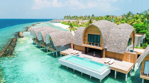 Overwater bungalows with private pools, connected by walkways, overlooking a turquoise sea and palm-fringed beach. - Ananea Madivaru Maldives (Madivaru)