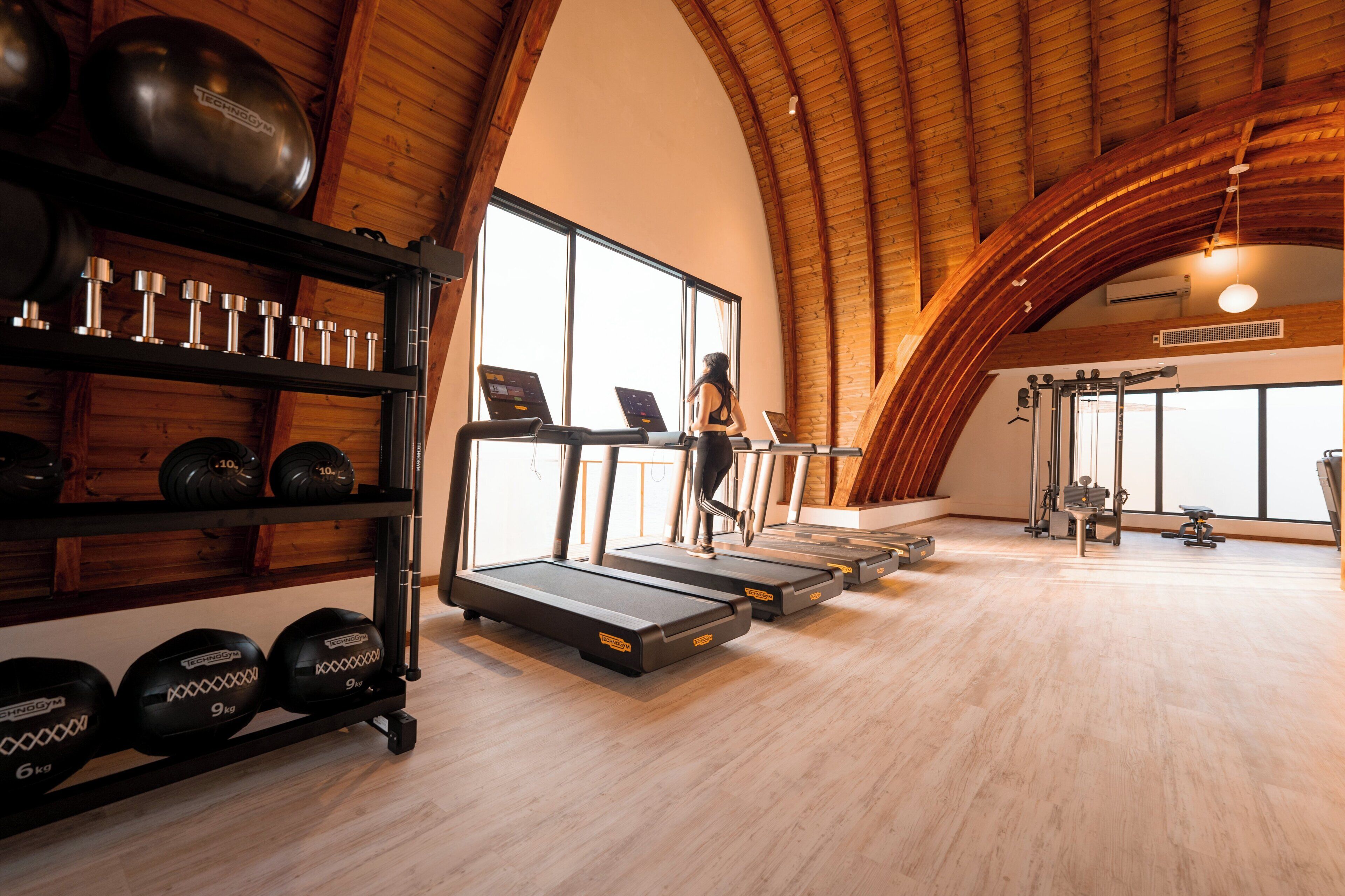 Ett gym med löpband, vikter och annan träningsutrustning.