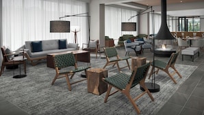 A spacious lobby with a sofa, chairs, a coffee table, and a fireplace. - Residence Inn by Marriott Seattle Northgate Station (Seattle)