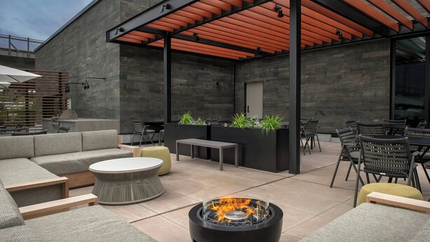 An outdoor patio with a fire pit, seating, and a covered area with a pergola. - Residence Inn by Marriott Seattle Northgate Station (Seattle)
