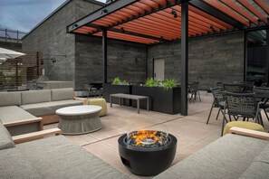 An outdoor patio with a fire pit, seating, and a covered area with a pergola. - Residence Inn by Marriott Seattle Northgate Station (Seattle)