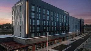 A modern hotel with a flat roof, large windows, and a covered outdoor seating area. - Residence Inn by Marriott Seattle Northgate Station (Seattle)