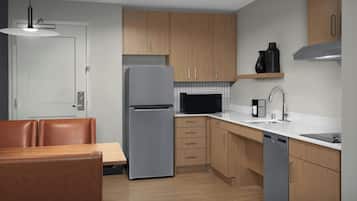 A modern kitchen with wooden cabinets, a stainless steel refrigerator, a microwave, and a dishwasher.