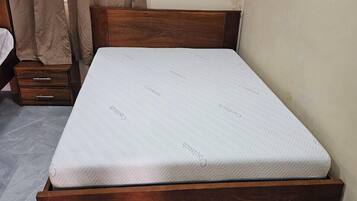 Una cama individual con estructura de madera y un colchón con la etiqueta 'Coletech'.