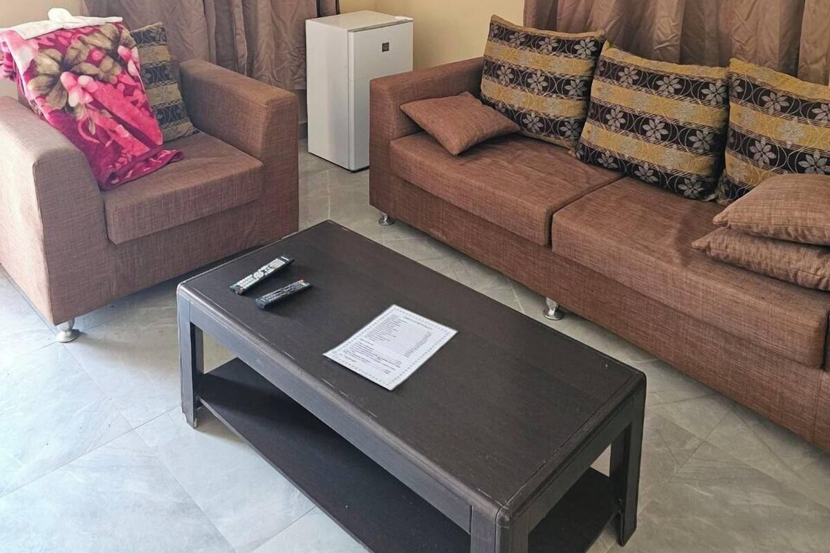 A living room with two sofas, a coffee table, and a small white appliance.