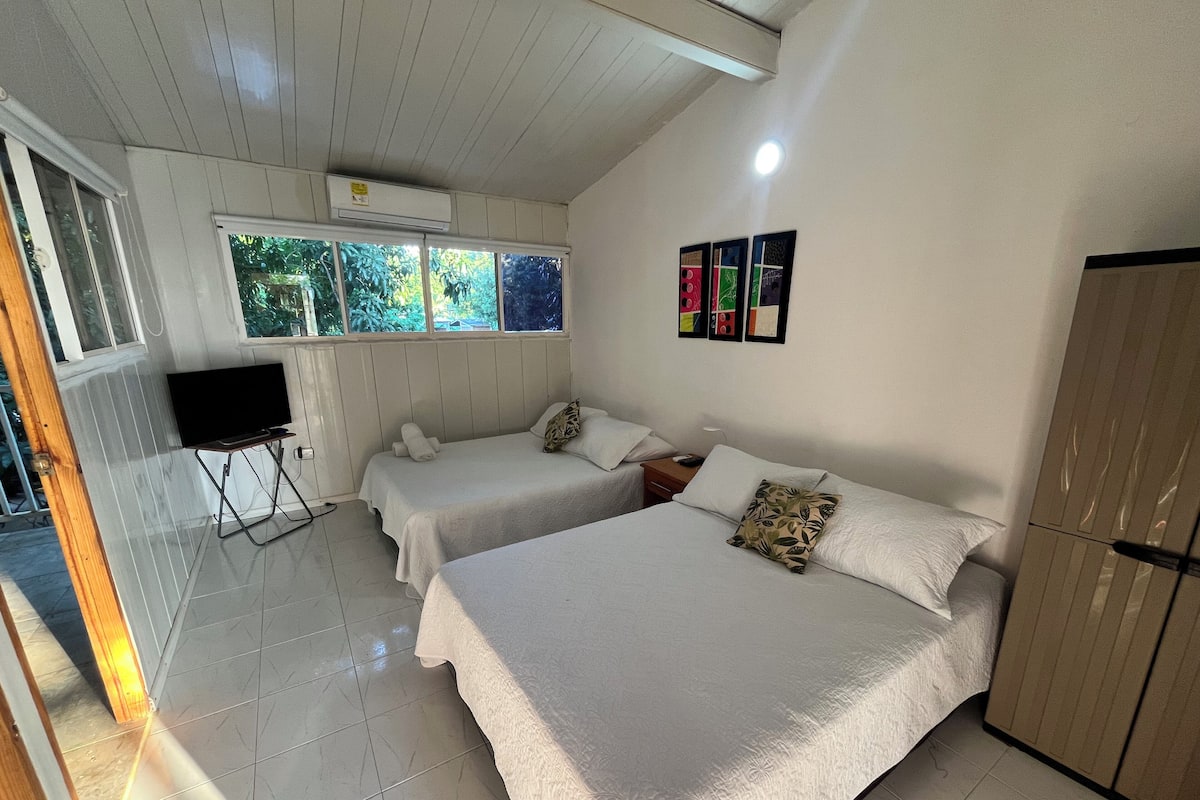 A room with two beds, a TV, and a wardrobe.
