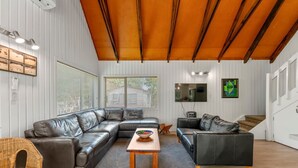 A modern living room with a sectional sofa, a wooden coffee table, and a TV on a stand.