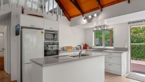 A modern kitchen with a central island, built-in appliances, and large windows.